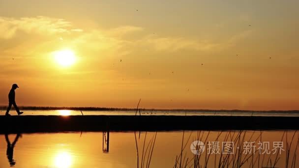 青少年沿着河剪影男孩视频