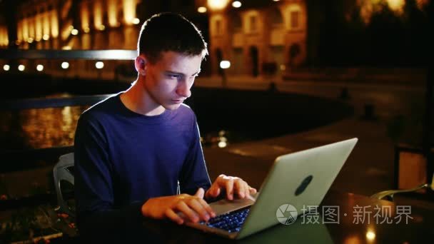 青少年使用一台笔记本电脑在深夜
