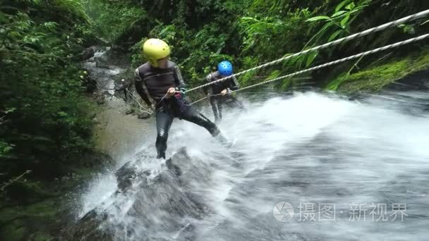 亚洲男子旅游瀑布速降