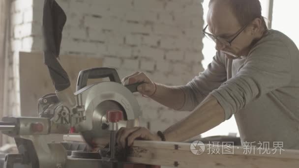 Professional carpenter cut long wooden board by circular saw. Fu