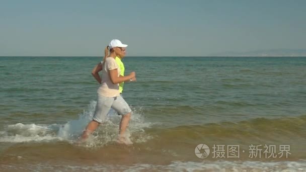 年轻的夫妇在浅海水中运行视频