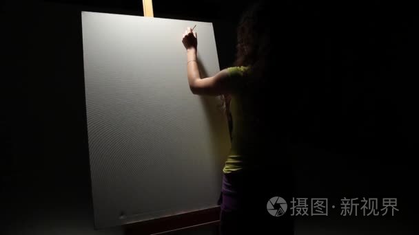 女艺术家用画笔在工作室绘画