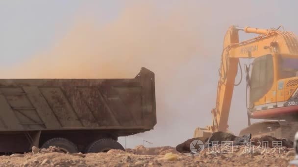 麦地那-沙特阿拉伯 2014 年 12 月 8 日-挖掘机铲加载自卸车
