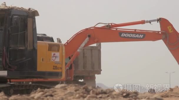 麦地那-沙特阿拉伯 2014 年 12 月 8 日-挖掘机铲加载自卸车