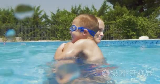 母亲和儿子在家里的游泳池玩乐视频