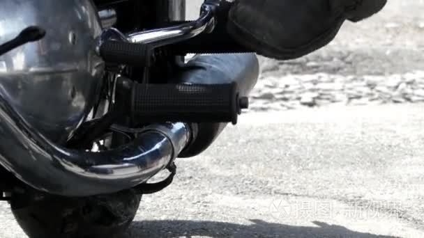 一个人的腿试图发动一辆黑色的摩托车