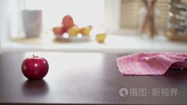 木制的桌子上的红苹果。一个成熟的红色的苹果放一张木头桌子的手