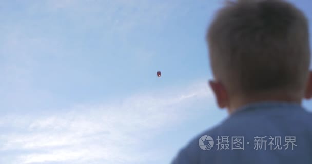 男孩向天空灯笼挥手