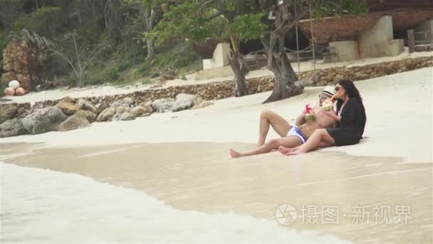 夫妇与椰子喝在沙滩上视频