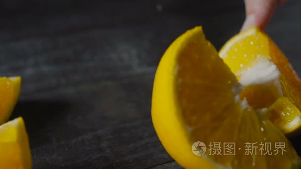 厨师把橙色水果切黑木制的桌子上