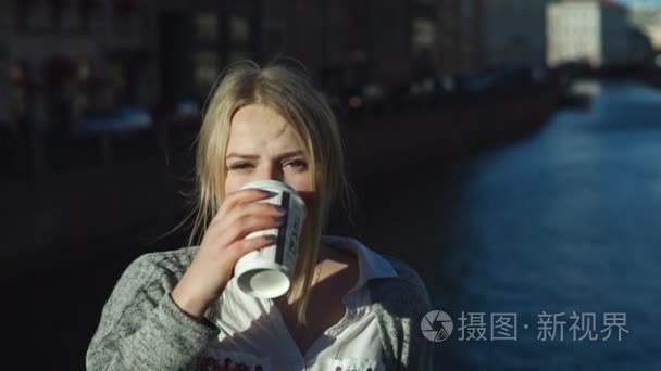 年轻女子在街上喝咖啡