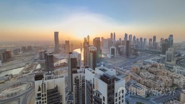 现代化的大城市与日落间隔拍摄风景鸟瞰图。阿拉伯联合酋长国的迪拜商业湾
