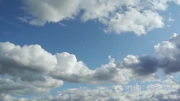 白色和一些乌云在蓝色的天空中移动的延时画面