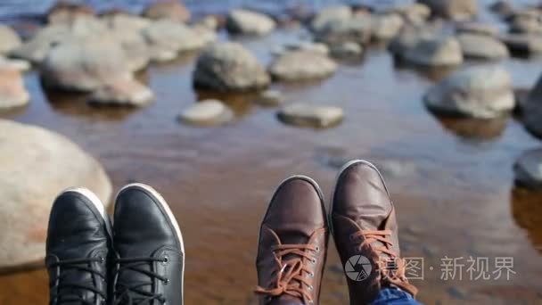 男性和女性的脚在鞋上的石滩视频