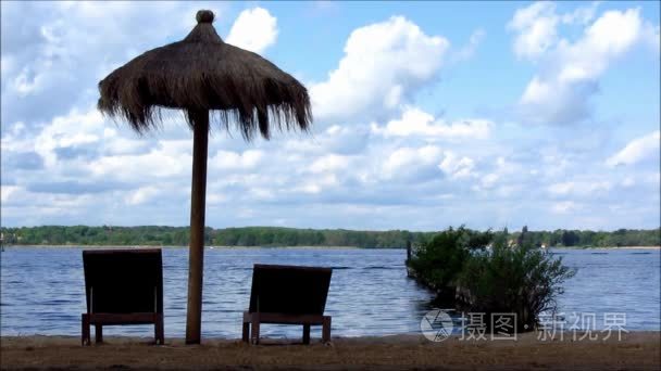 折叠式躺椅和伞在湖视频