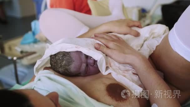 女人坚持胃新生婴儿，在出生之后。妇产科医院。妇科医生。宝贝