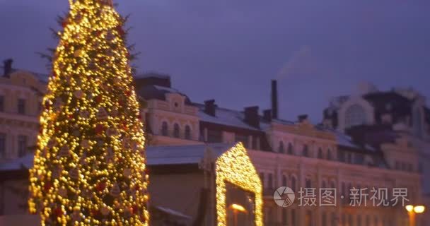 在新年的旋转木马电视屏幕人树圣诞老人圣诞老人服装老式建筑人家庭中的人在走在索非亚广场庆祝基辅