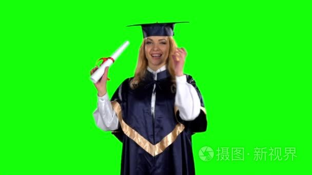 Woman graduate in gown with diploma. Green screen. Slow motion