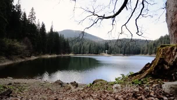 深湛蓝湖山山脚的岩石海岸视频