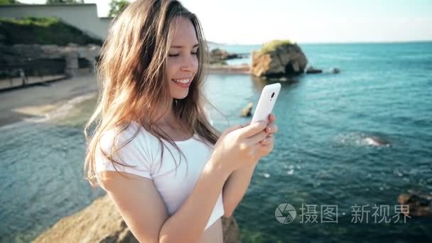 智能手机的女人 sms 短信海滩日落时分在智能手机上使用应用程序。混合