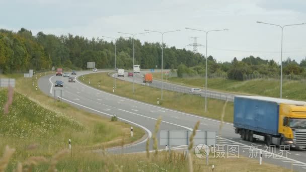 大量的卡车和轿车在公路上移动视频