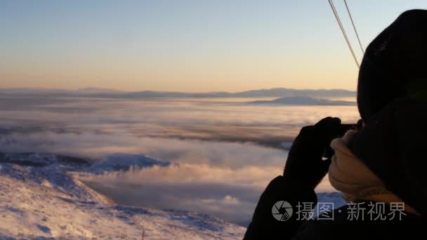 年轻女子从山顶，瑞典在山谷拍摄低晚霞的图片