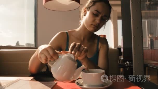 女孩在咖啡馆里倒入一杯茶视频