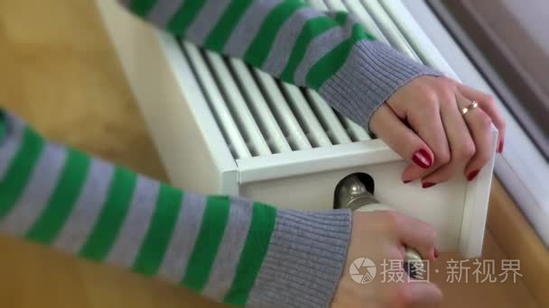 气候变暖对现代散热器在家里手的女孩