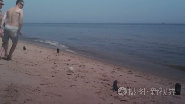 两个家伙在海边沙滩上玩耍迷你足球