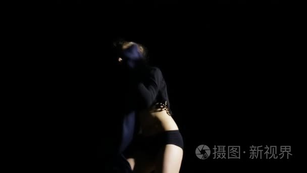 性感的女人在黑色背景上飞舞布视频
