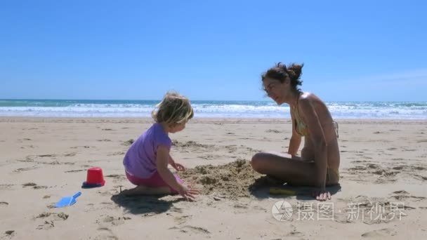 母亲和小宝宝玩沙滩视频