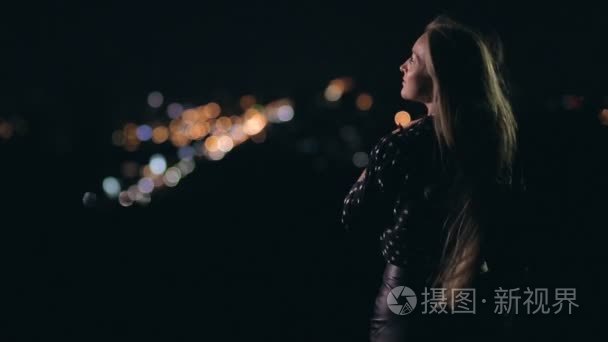 女人享受夜晚的城市从观景台视频