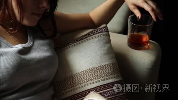 悲伤孤独的女子在黑暗中喝酒.玻璃在大家关注的焦点.女性酗酒短视频