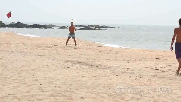 身份不明的男子在海滩上玩飞盘视频