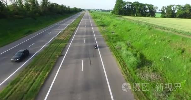 过去的领域的道路上行驶的汽车。过顶球视频