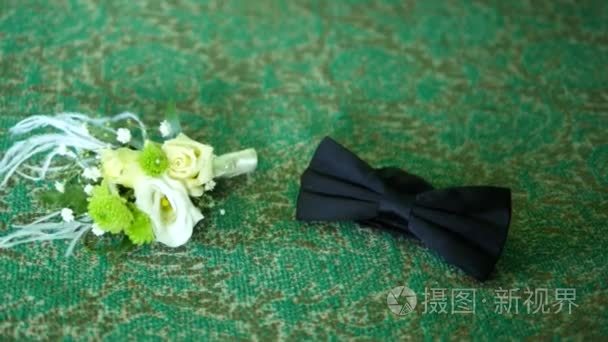 黑领结和漂亮胸花的绿色背景视频