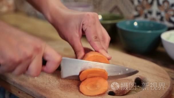 女人的手在砧板上的切胡萝卜