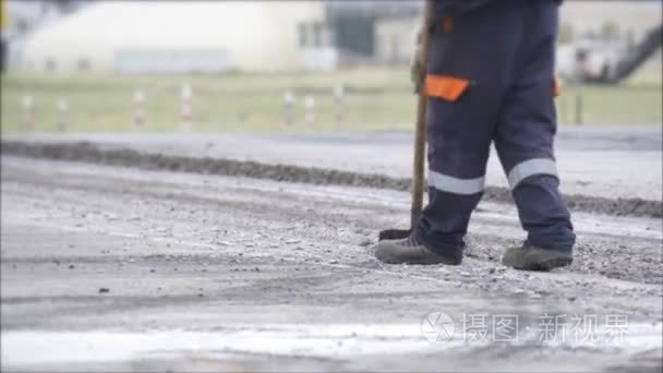 道路施工工人调配沥青使用耙子视频