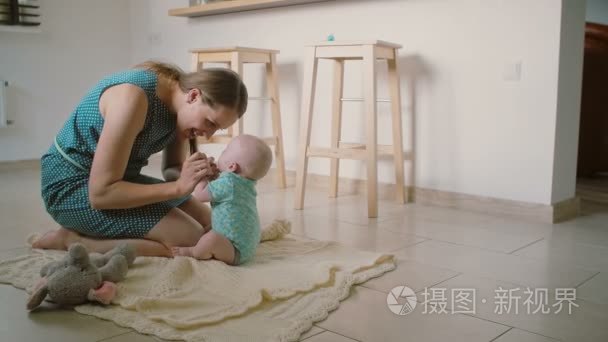 A beautiful young mother lifts up her adorable smiling baby help