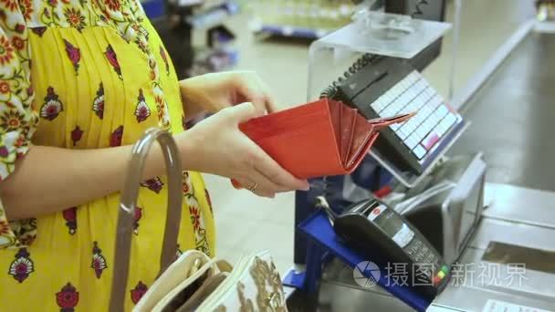孕妇获取钱从她的钱包,若要计算在超市里购买的物品短视频