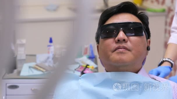 牙医拍照相机、 与病人坐在椅子上笑