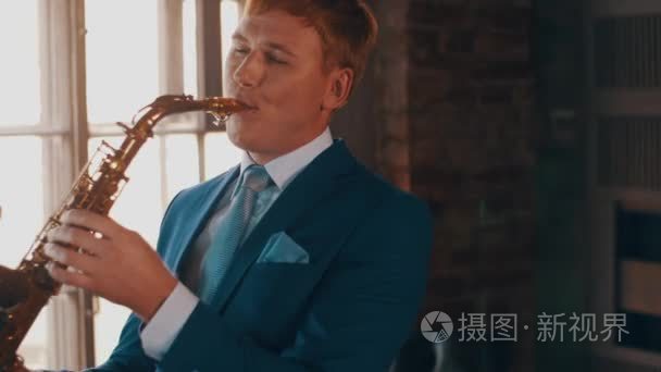 Saxophonist in blue suit play on golden saxophone. Live performa