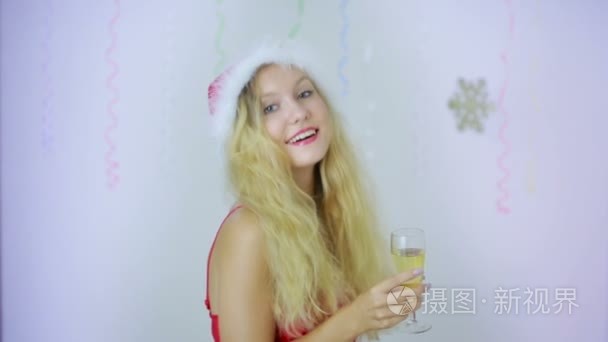 微笑美女女孩在圣诞老人的帽子给你一杯香槟视频