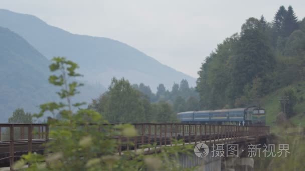 客运列车通过这座桥在山区河流视频