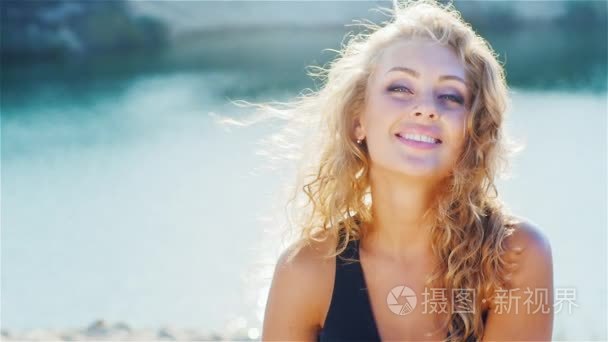 Young woman smiling into the camera  playing with her beautiful 