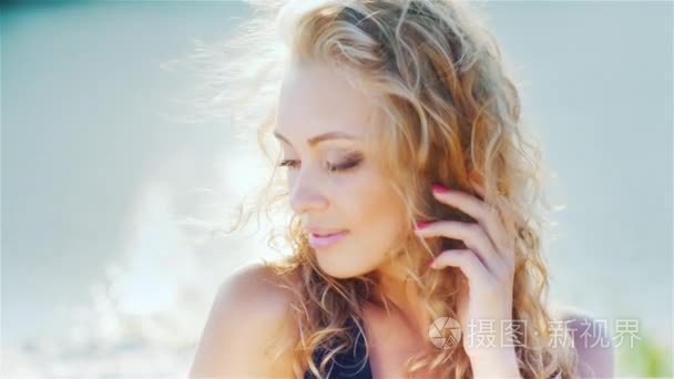 Young woman smiling into the camera  close-up shot. Wind playing