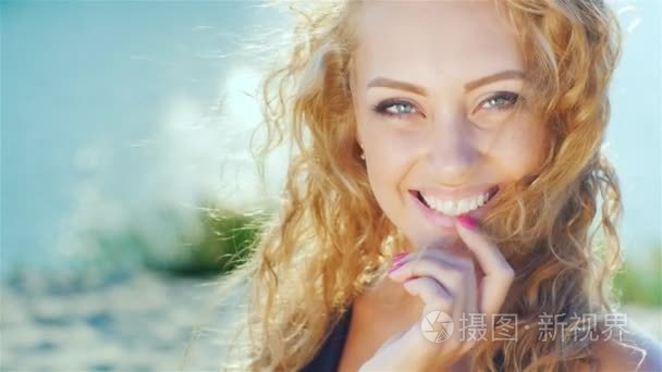 Closeup of a beautiful young woman smiling at the camera. Sunny