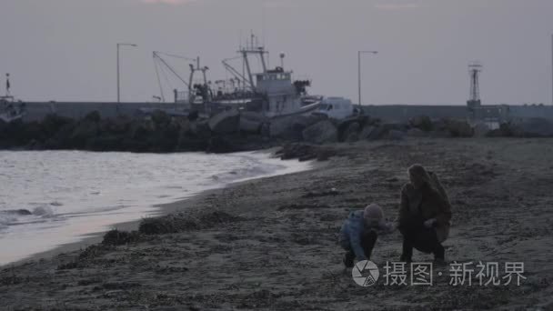 母亲和孩子在海里扔石头视频