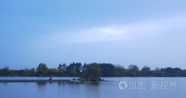 Man Gets up Walks by Wooden Pier on River Small Island Overgrown