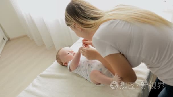 美丽的年轻母亲脱衣她 3 个月大男婴躺在更改表